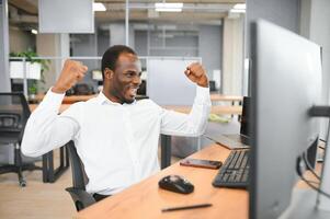 africano americano comerciante trabalho às computador com exibido tempo real ações foto