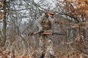 Caçando permitir. homem brutal guarda-caça natureza fundo. caçador gastar lazer Caçando. caçador aguarde rifles. foco e concentração do com experiência caçador. Caçando e armadilha temporadas foto