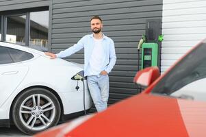 uma homem cobranças a elétrico carro foto