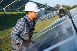 indiano homem dentro uniforme em solar Fazenda. competente energia engenheiro controlando trabalhos do fotovoltaico células foto