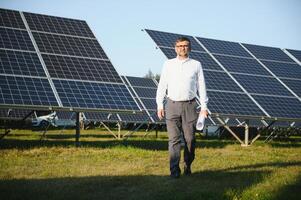 Senior engenheiro trabalhando em solar painel Fazenda. a conceito do verde energia foto