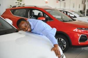 bonito homem é em pé perto dele Novo carro e sorridente foto