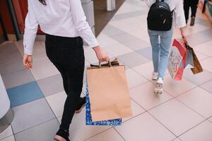 compras tempo, fechar-se do Adolescência menina pernas com compras bolsas às compras shopping center. foto