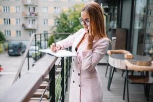 o negócio mulher em a telefone às escritório. jovem o negócio mulher tendo telefone ligar às a escritório. sorridente o negócio mulher. bonita jovem o negócio usando Smartphone às a loft escritório. foto