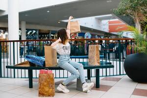 varejo, gesto e venda conceito - sorridente Adolescência menina com muitos compras bolsas às shopping center. compras conceito foto