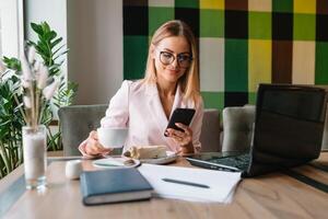 o negócio mulher em a telefone às escritório. jovem o negócio mulher tendo telefone ligar às a escritório. sorridente o negócio mulher. bonita jovem o negócio usando Smartphone às a loft escritório. foto