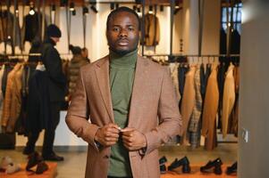 jovem africano homem compras dentro roupas loja foto