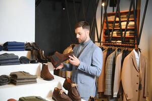 retrato do bonito jovem homem comprando sapatos dentro a loja foto