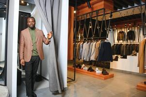 jovem africano homem compras dentro roupas loja foto