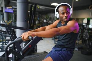 saudável africano americano homem exercício dentro Academia foto