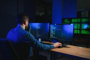 masculino programador trabalhando em Área de Trabalho computador às branco escrivaninha dentro escritório foto