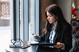 jovem empresária usando tábua computador dentro café fazer compras. foto