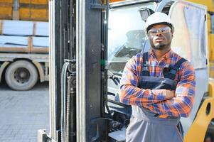 africano americano homem às trabalhar. profissional Operação Engenharia. jovem trabalhador empilhadeira motorista foto