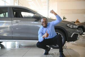 carro comprador. Preto cara escolhendo Novo automóvel dentro concessionária loja foto