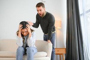 a agitado e chateado marido gritos e parece às dele esposa, uma brigar entre cônjuges. família mal-entendido, brigar foto