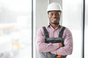 sorridente construção trabalhador com braços cruzado às local foto