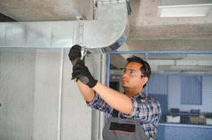 hvac indiano trabalhador instalar canalizado tubo sistema para ventilação e ar condicionamento. cópia de espaço foto