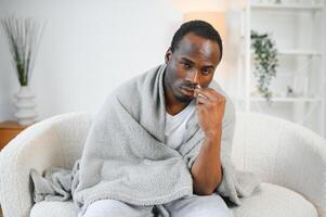 frio e gripe tratamento. doente africano americano homem usando nasal spray foto