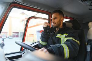 bombeiro usando rádio conjunto enquanto dirigindo fogo caminhão foto