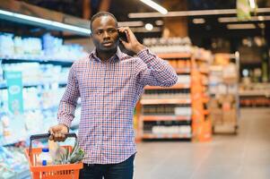 jovem africano homem comprando dentro mercearia seção às supermercado foto