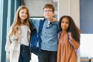 retrato do crianças em pé dentro elementar escola corredor foto