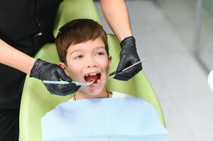 fechar-se do pequeno Garoto abertura dele boca durante dental checar foto