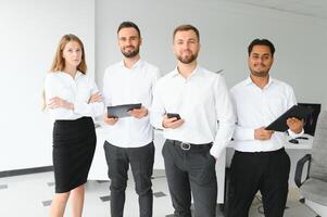 feliz pessoas de negócio rindo enquanto colaborando em uma Novo projeto dentro a escritório. grupo do diverso pessoas de negócio trabalhando juntos dentro uma moderno área de trabalho foto