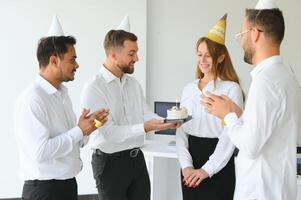 o negócio equipe a comemorar uma aniversário dentro a escritório. foto