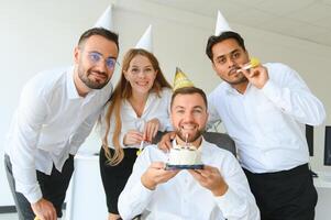 corporativo festa e pessoas conceito - feliz equipe com bolo a comemorar colega aniversário às escritório foto