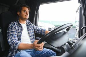 retrato do uma jovem bonito indiano caminhão motorista. a conceito do logística e frete transporte. foto