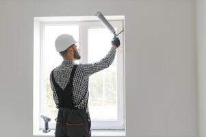 trabalhador da construção civil instalando janela em casa foto