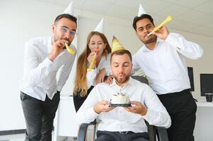 surpresa. misturado raça feliz pessoas a comemorar uma aniversário do colega dentro a moderno escritório foto