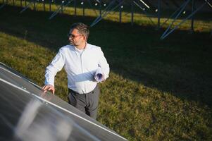 Senior engenheiro trabalhando em solar painel Fazenda. a conceito do verde energia foto