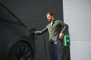 uma homem cobranças a elétrico carro foto