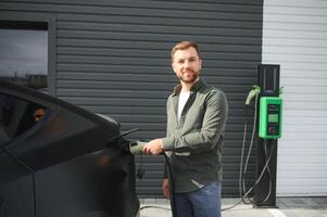 uma homem cobranças a elétrico carro foto