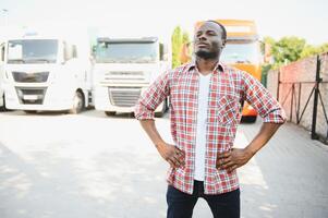 retrato africano masculino feliz sorridente confiante positivo perto caminhão. jovem homem xadrez camisa proprietário caminhão motorista dentro o negócio grandes transporte polegares acima satisfeito serviço comercial dirigindo licença Treinamento foto