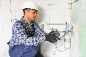 indiano encanador instalando água equipamento - metro, filtro e pressão redutor foto