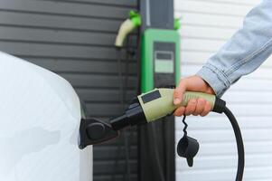 fechar acima do mão segurando poder cabo para ambientalmente amigáveis zero emissão elétrico carro foto