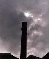 industrial tubo e cinzento céu fundo, tormentoso céu papel de parede foto