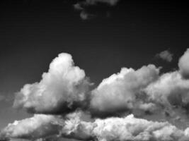 Preto e branco nuvens dentro a céu fundo foto