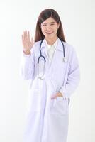 retrato. lindo ásia fêmea médico sorridente, levantando mãos para saudar. conceito do médico Serviços dentro hospitais. branco fundo foto