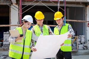 arquitetos e engenheiros e construtores segurando uma projeto discutindo construção construção planos às a ao ar livre local. real Estado projeto conceitos, construção construção cooperação. foto