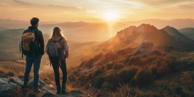 uma jovem casal do Viajantes ficar de pé em uma Colina e Assistir a pôr do sol. caminhada turismo conceito foto