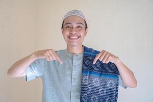 muçulmano ásia homem apontando a ligação gesto quando Ramadã celebração. a foto é adequado para usar para Ramadhan poster e muçulmano conteúdo meios de comunicação.