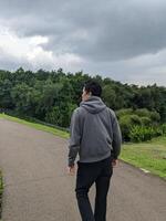 homem caminhando em a parque quando dia tempo. a foto é adequado para usar para calma curtiu atividade, lazer atividade e parque fundo.