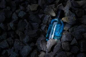 perfume azul transparente garrafa dentro cascalho ou coral fundo foto
