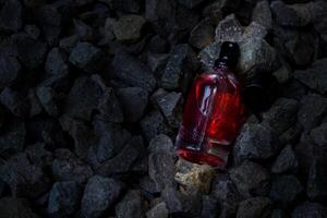 perfume vermelho transparente garrafa dentro cascalho ou coral fundo foto