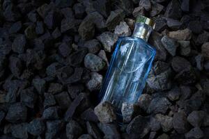 perfume azul transparente garrafa dentro cascalho ou coral fundo foto