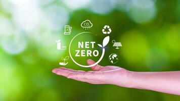 internet zero e carbono neutro conceitos, internet zero estufa gás emissões alvo, clima neutro grandes estratégia, homem de negocios segurando netzero ícone. foto