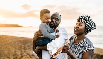 feliz africano família tendo Diversão em a de praia durante verão Férias foto